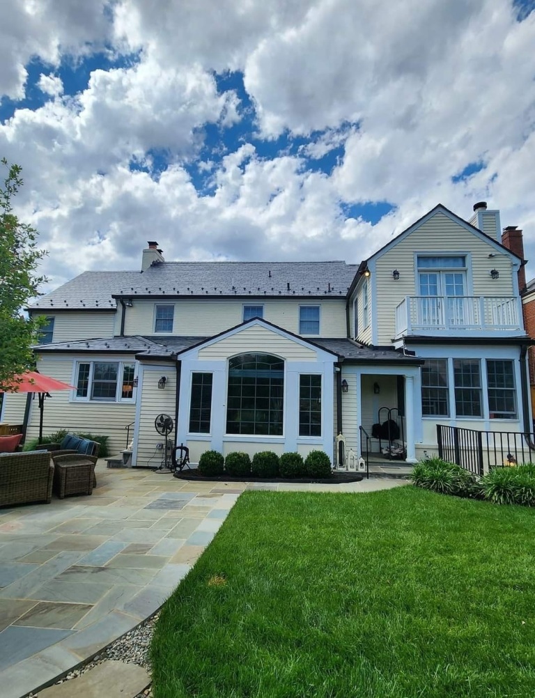 Charming suburban home with large windows and a lush green lawn