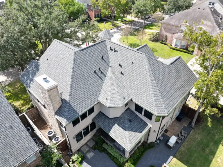 Aerial view of a modern suburban house with a complex roof design.
