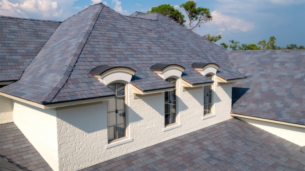 A picturesque residential roof with slate shingles and arched dormer windows.