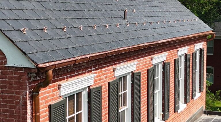 Historic brick building with slate roof and copper gutters.