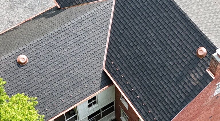 Black shingled roof with copper domes on a residential building.