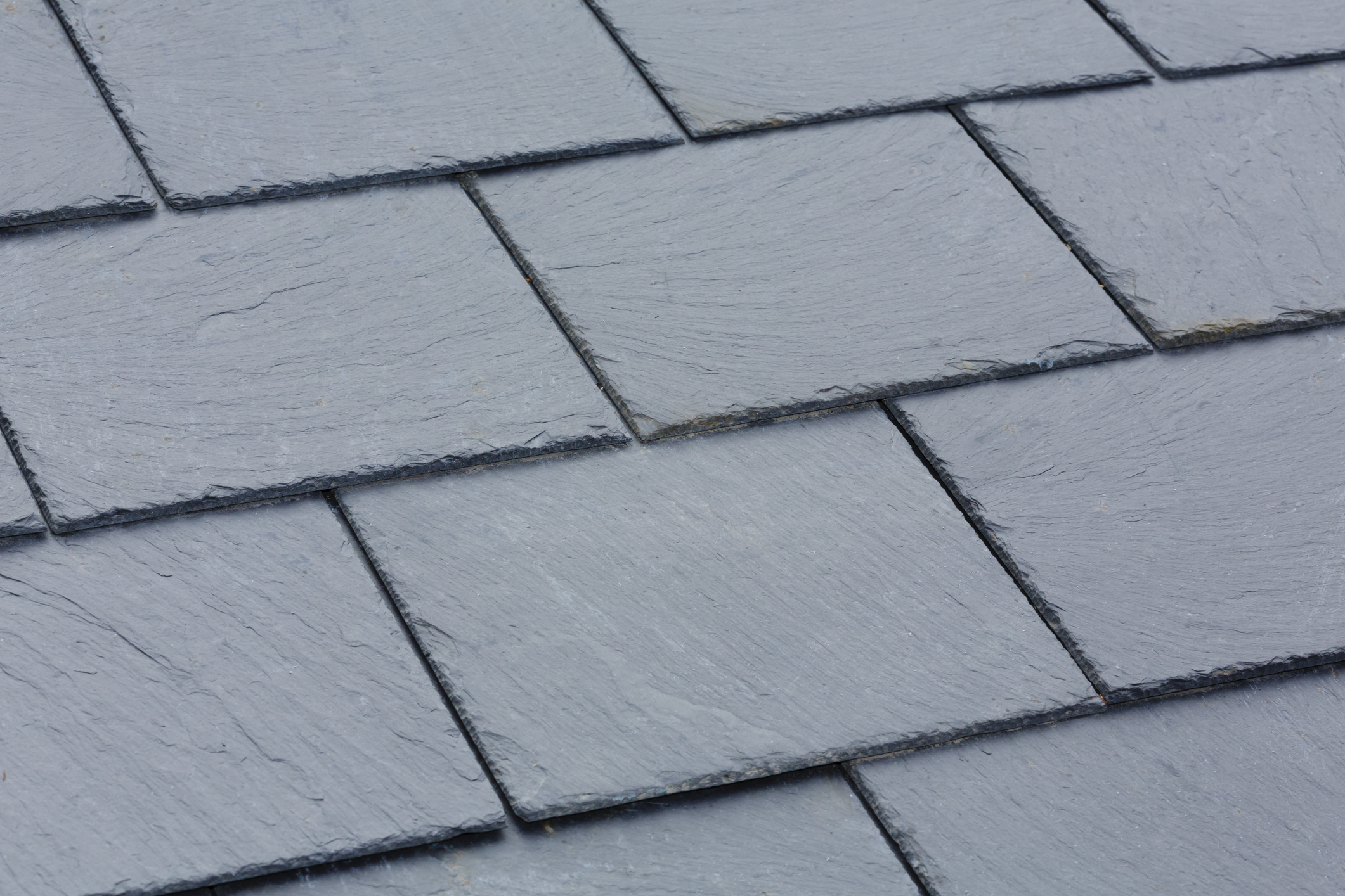 Close-up view of overlapping gray slate roof tiles.