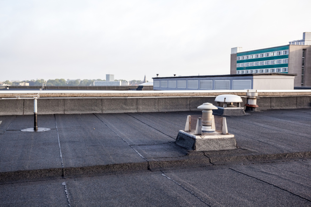 Industrial rooftop with exhaust vents and cityscape view