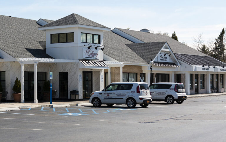 Shopping plaza with restaurants and parked delivery cars