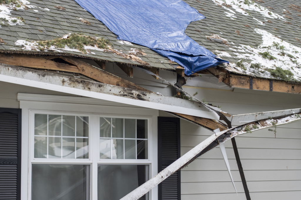 Damaged roof with tarp and broken structure
