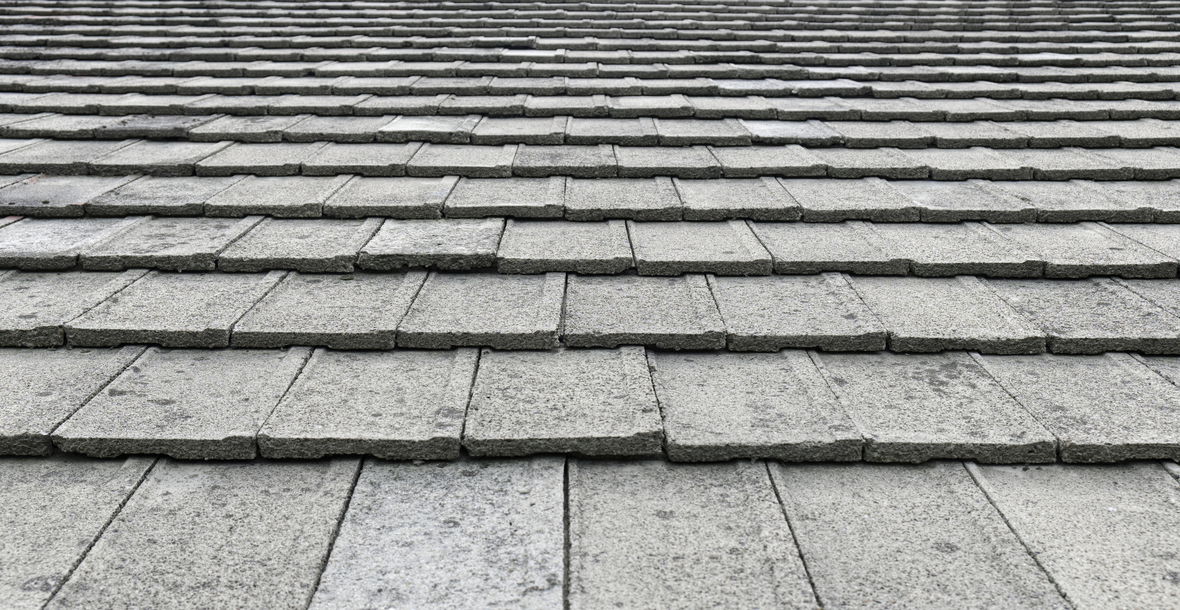 Close-up image of gray textured roof shingles in rows.