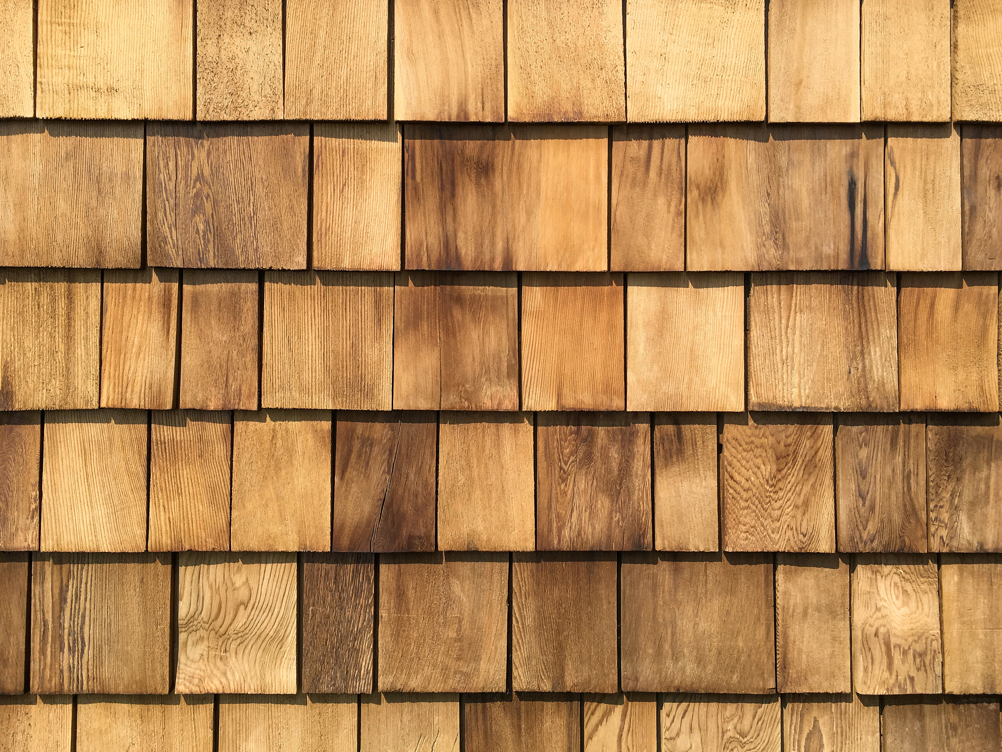 Close-up of wooden shingles forming a textured, rustic wall background